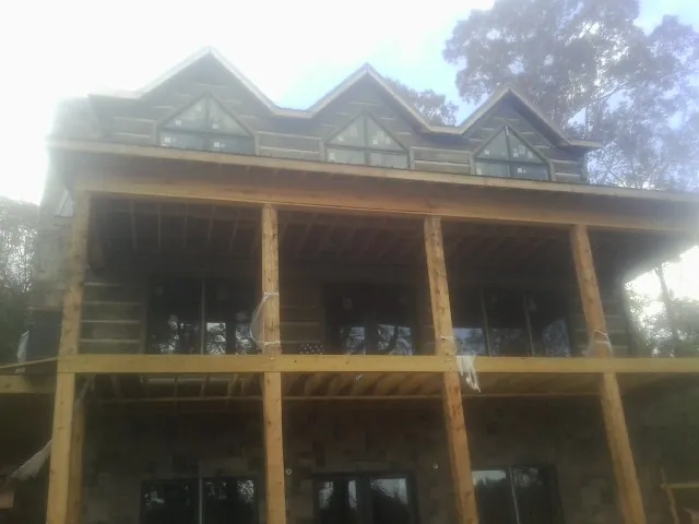 Dormers and porch framing on a large log home under construction — Roof Coating work by our crew in Catawissa