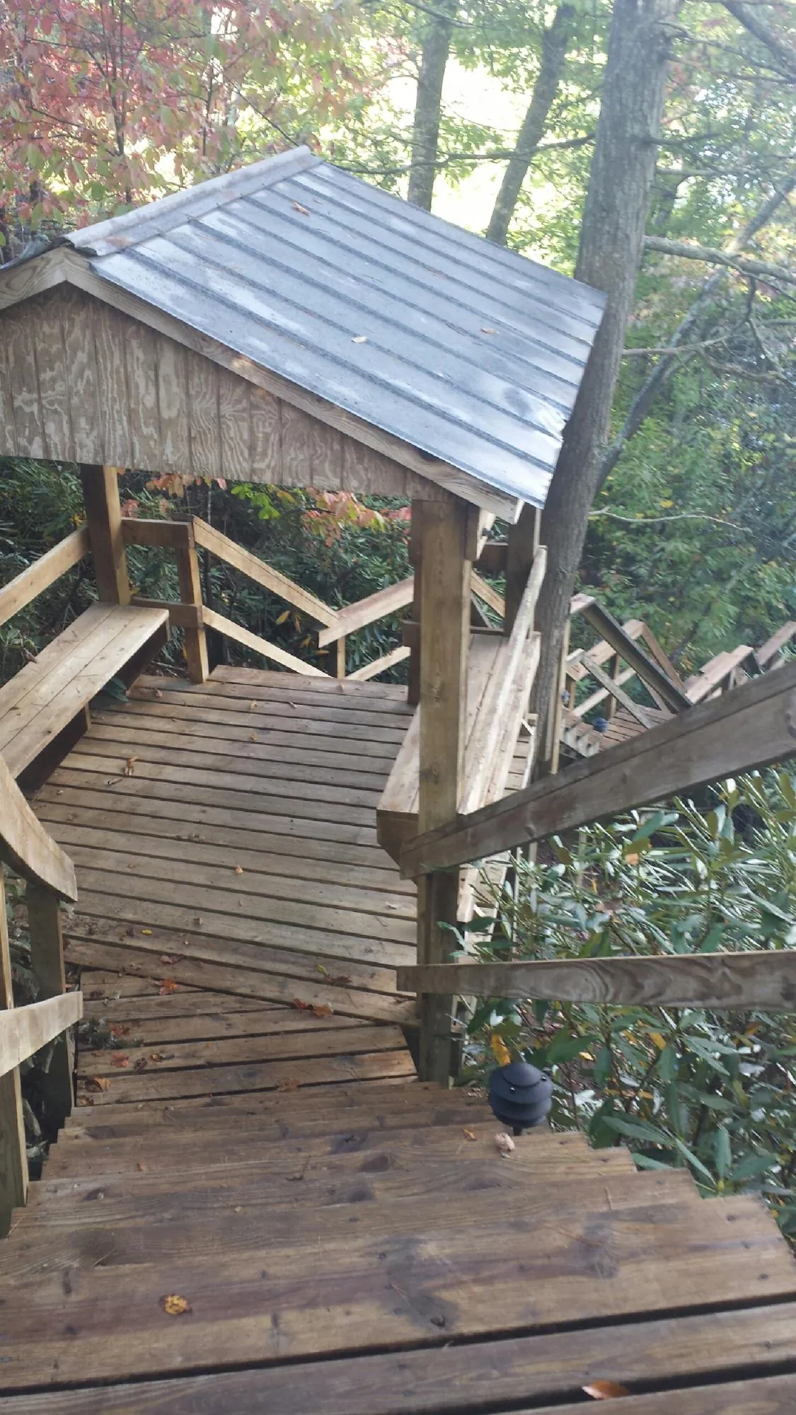 Metal roofed shelter over wooden steps on a wooded walkway — Skylight Repair & Installation work by our crew in Catawissa