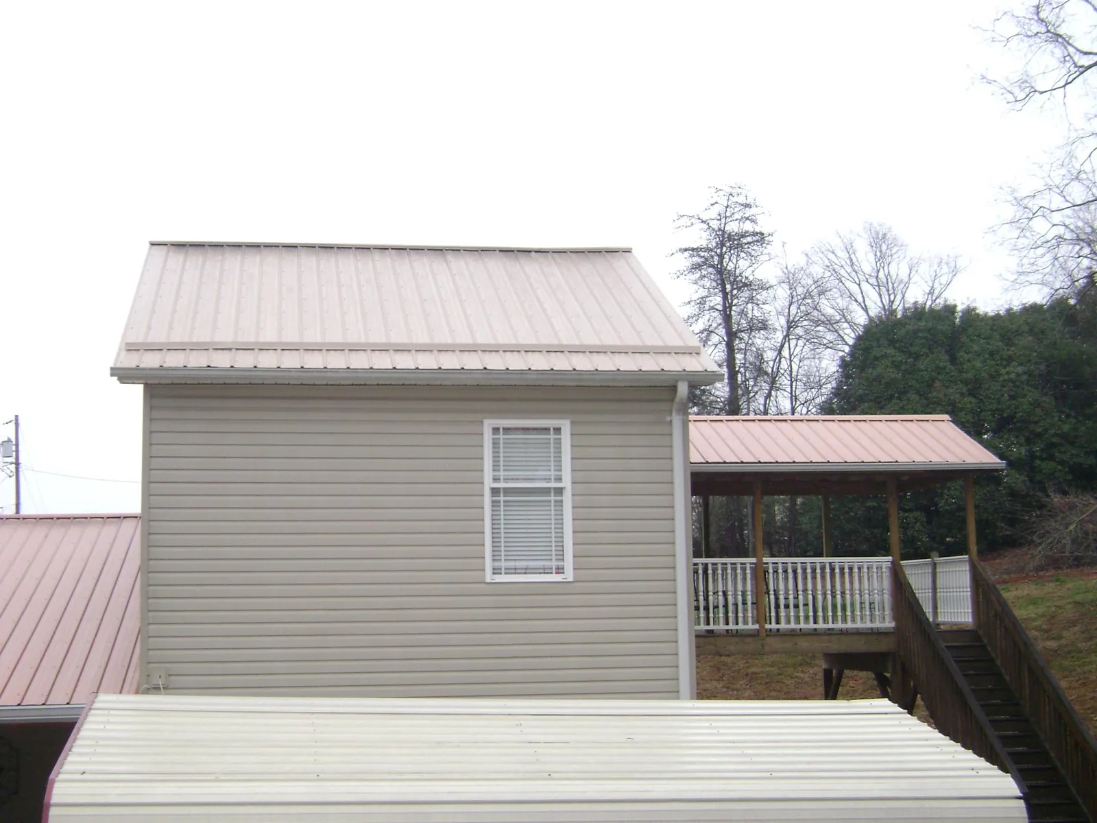 Tan metal roofs on a two story addition and attached porch, from a Roof Replacement job in Catawissa